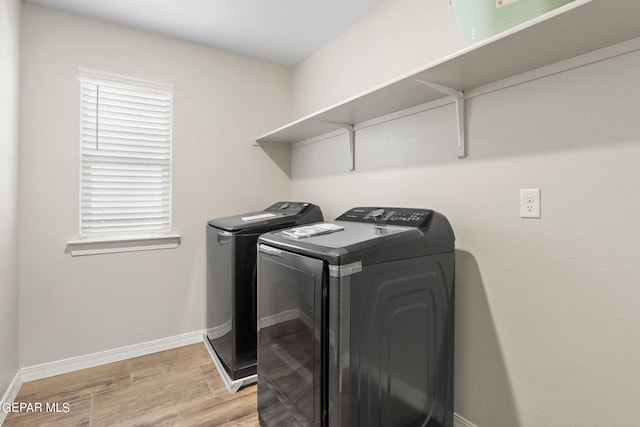 clothes washing area with light wood-type flooring and washing machine and dryer