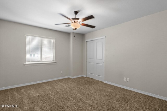 empty room featuring ceiling fan and carpet flooring