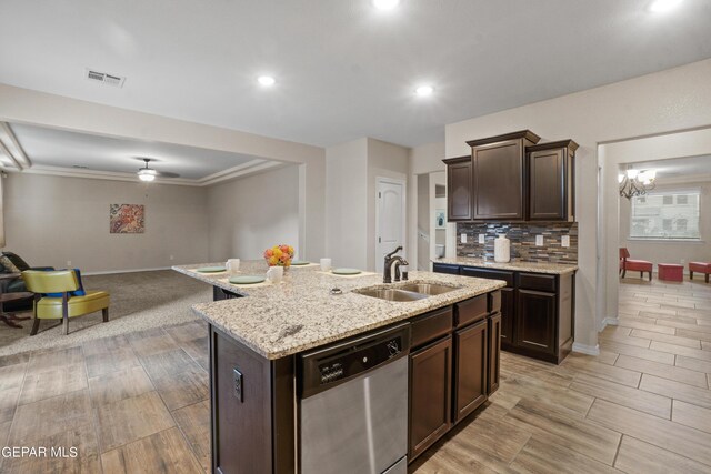 kitchen with light hardwood / wood-style floors, dark brown cabinets, a center island with sink, stainless steel dishwasher, and sink