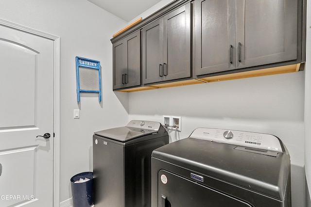 washroom with cabinets and washing machine and clothes dryer