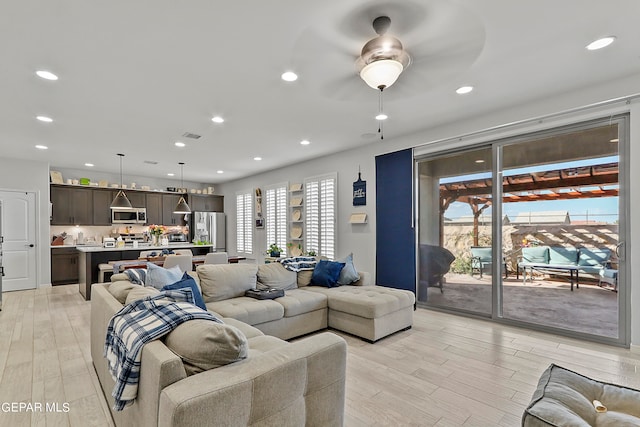 living room featuring light hardwood / wood-style floors and ceiling fan