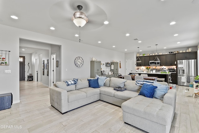 living room featuring ceiling fan and light wood-type flooring