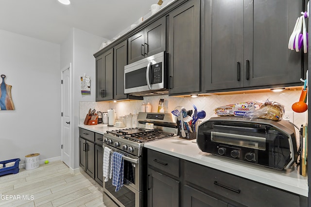 kitchen featuring light hardwood / wood-style floors, appliances with stainless steel finishes, and tasteful backsplash