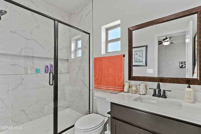 bathroom featuring vanity, toilet, ceiling fan, and an enclosed shower