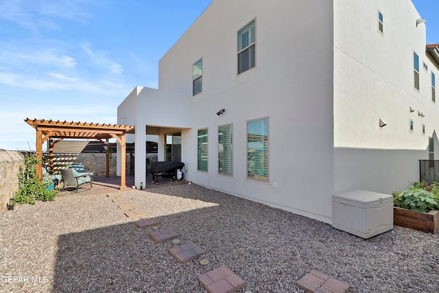 back of property featuring a pergola and a patio