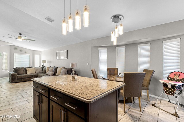 kitchen featuring ceiling fan, a wealth of natural light, vaulted ceiling, and a center island