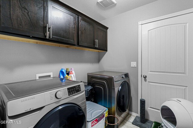 laundry area with independent washer and dryer and cabinets