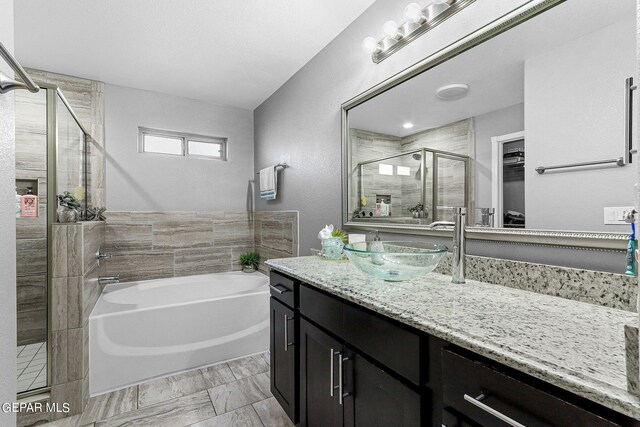 bathroom featuring independent shower and bath and vanity