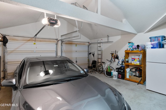 garage with a garage door opener and white refrigerator