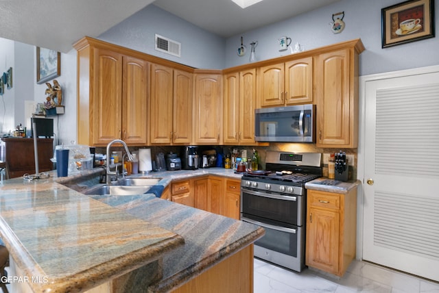 kitchen featuring light stone counters, appliances with stainless steel finishes, sink, and tasteful backsplash