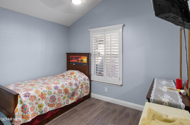 bedroom with vaulted ceiling, ceiling fan, and dark wood-type flooring