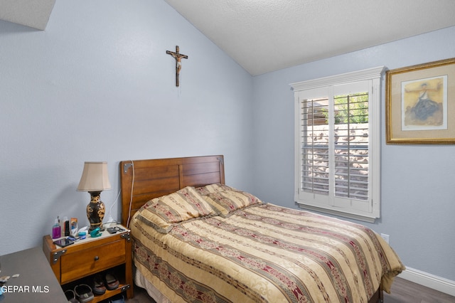 bedroom with wood-type flooring and lofted ceiling