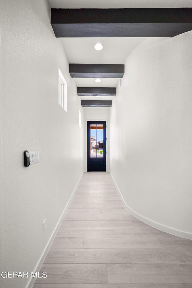 hall with light hardwood / wood-style floors and beamed ceiling