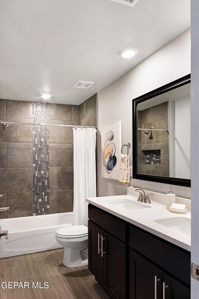 full bathroom with shower / bath combo, vanity, and toilet