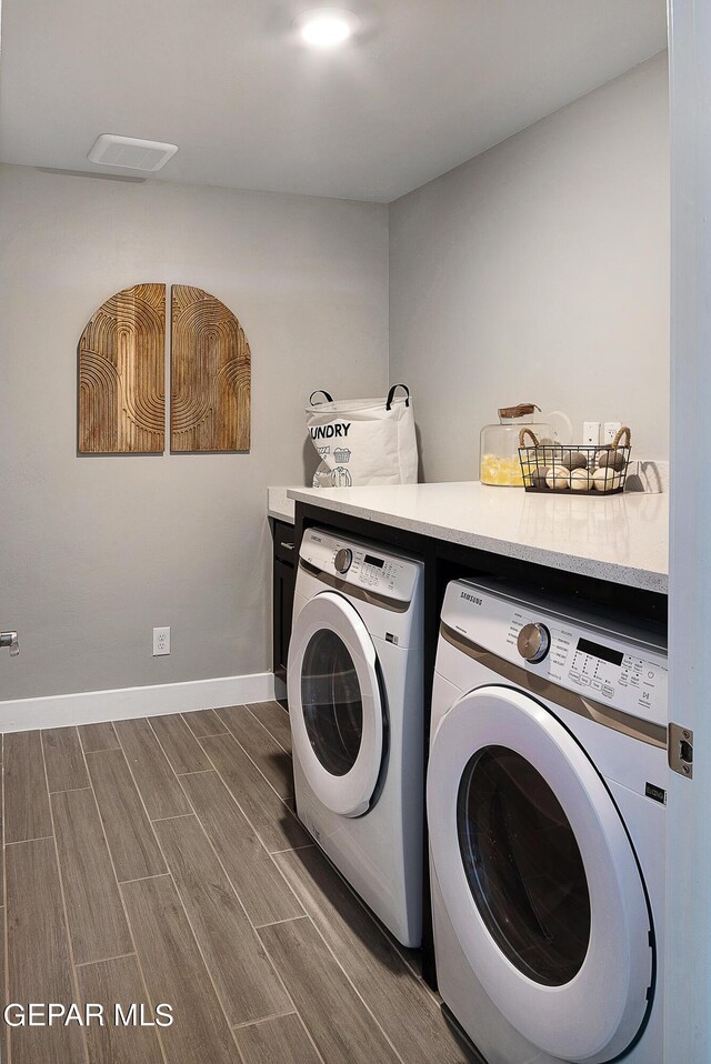 clothes washing area featuring wood-type flooring and washing machine and dryer