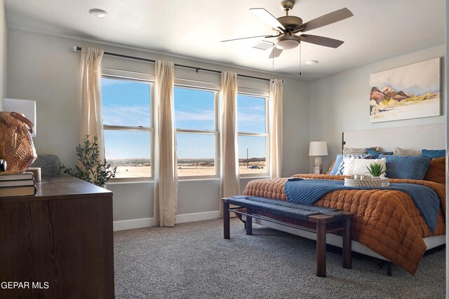 carpeted bedroom with multiple windows and ceiling fan