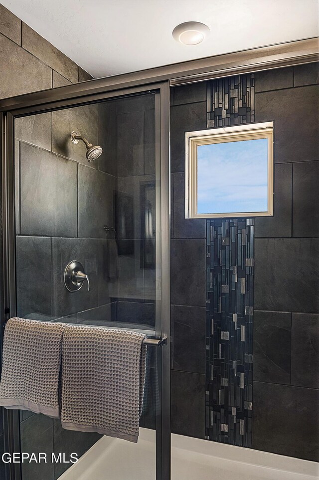 bathroom featuring a shower with shower door