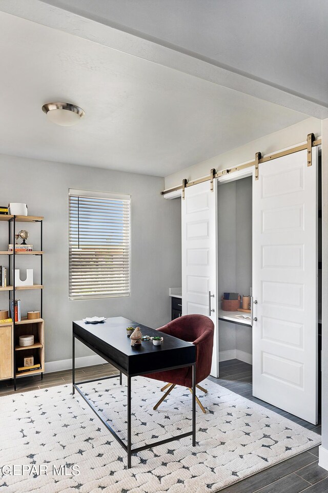 office with wood-type flooring and a barn door