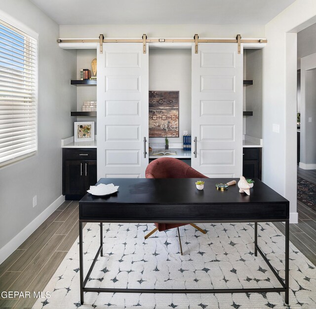 office space with a barn door and hardwood / wood-style flooring