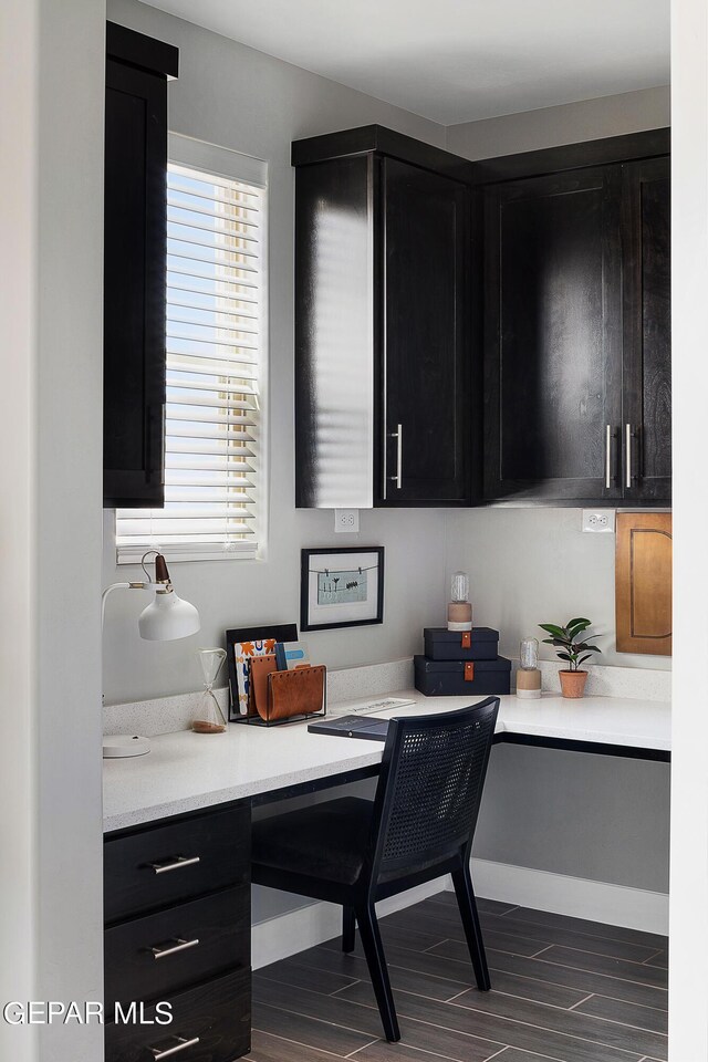 office featuring built in desk and dark hardwood / wood-style flooring