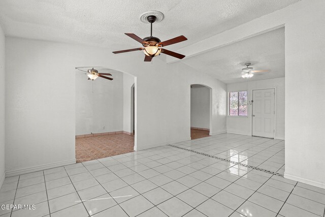 entrance foyer with ceiling fan, light tile patterned floors, and a textured ceiling