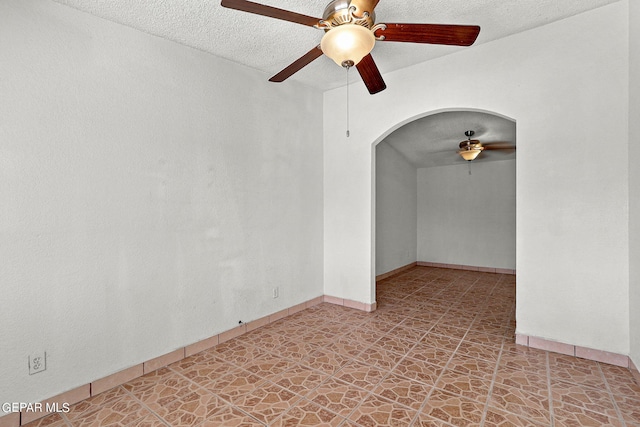 unfurnished room with ceiling fan and a textured ceiling