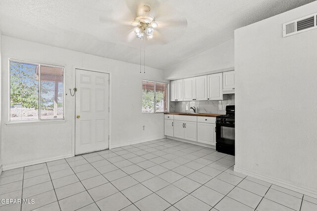 kitchen with white cabinets, ceiling fan, plenty of natural light, and black gas range