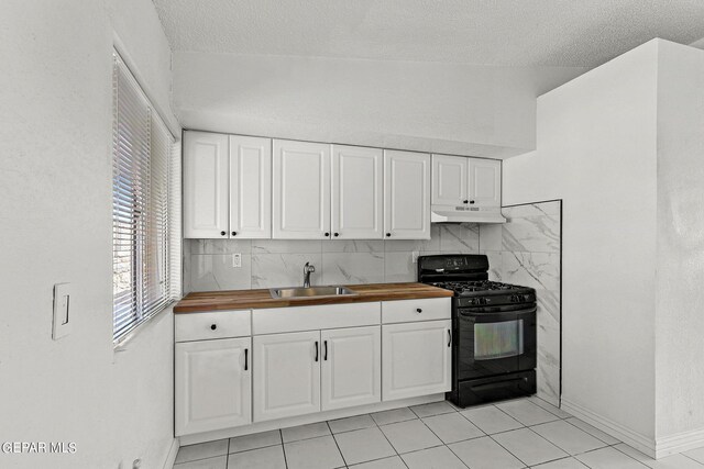 kitchen featuring butcher block countertops, black range with gas stovetop, backsplash, and sink