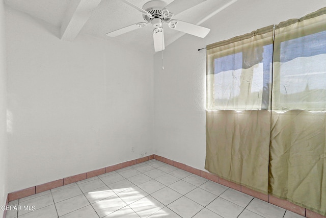 unfurnished room with beam ceiling, ceiling fan, and light tile patterned floors