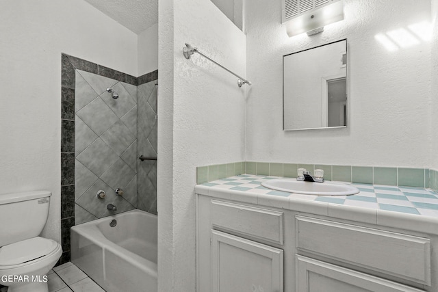 full bathroom with tiled shower / bath, vanity, and toilet