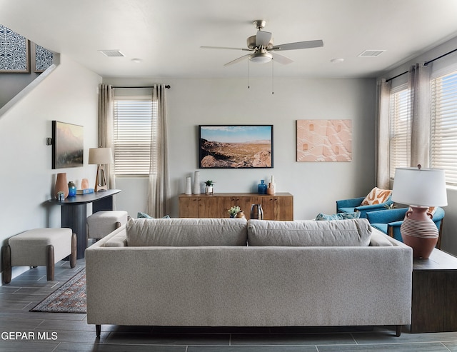 living room featuring ceiling fan and dark hardwood / wood-style flooring