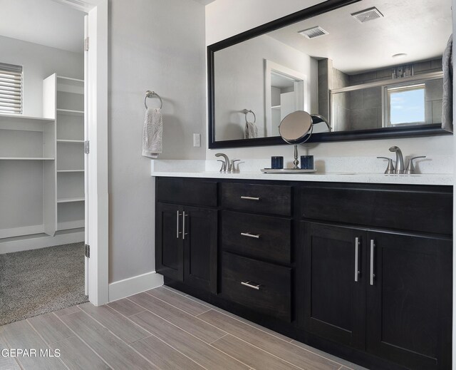 bathroom with vanity and a shower with shower door