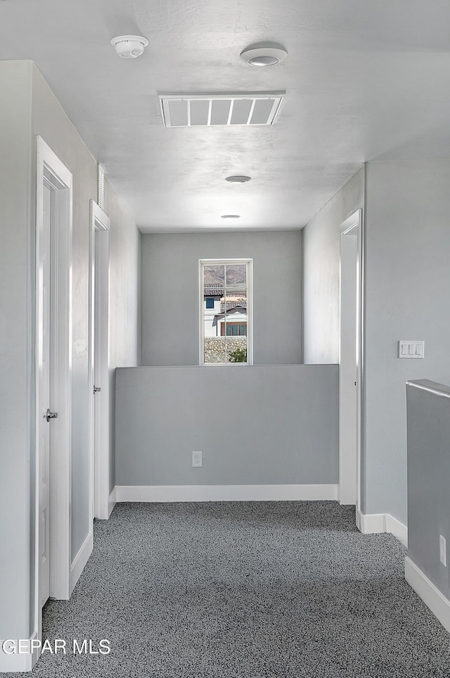 empty room with dark colored carpet