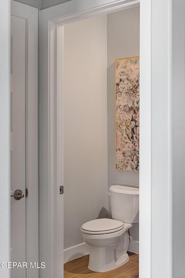 bathroom with hardwood / wood-style flooring and toilet