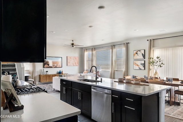 kitchen with light hardwood / wood-style floors, dishwasher, ceiling fan, a kitchen island with sink, and sink