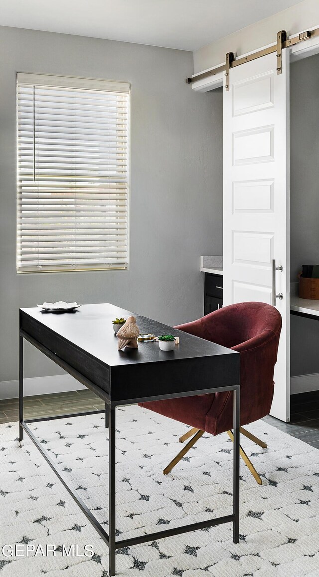 interior space with a barn door and wood-type flooring