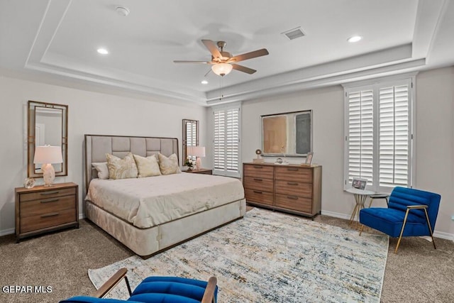 bedroom featuring ceiling fan, a raised ceiling, and carpet