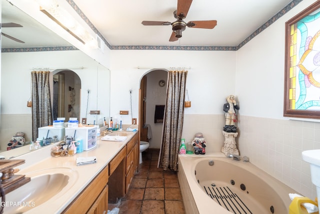 bathroom featuring vanity, ceiling fan, a tub, and toilet