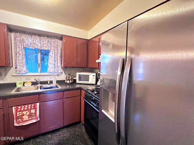 kitchen with stainless steel fridge, vaulted ceiling, exhaust hood, gas stove, and sink