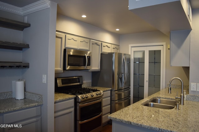 kitchen featuring light stone counters, stainless steel appliances, sink, and white cabinetry