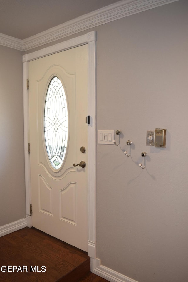 entryway with dark hardwood / wood-style floors and crown molding