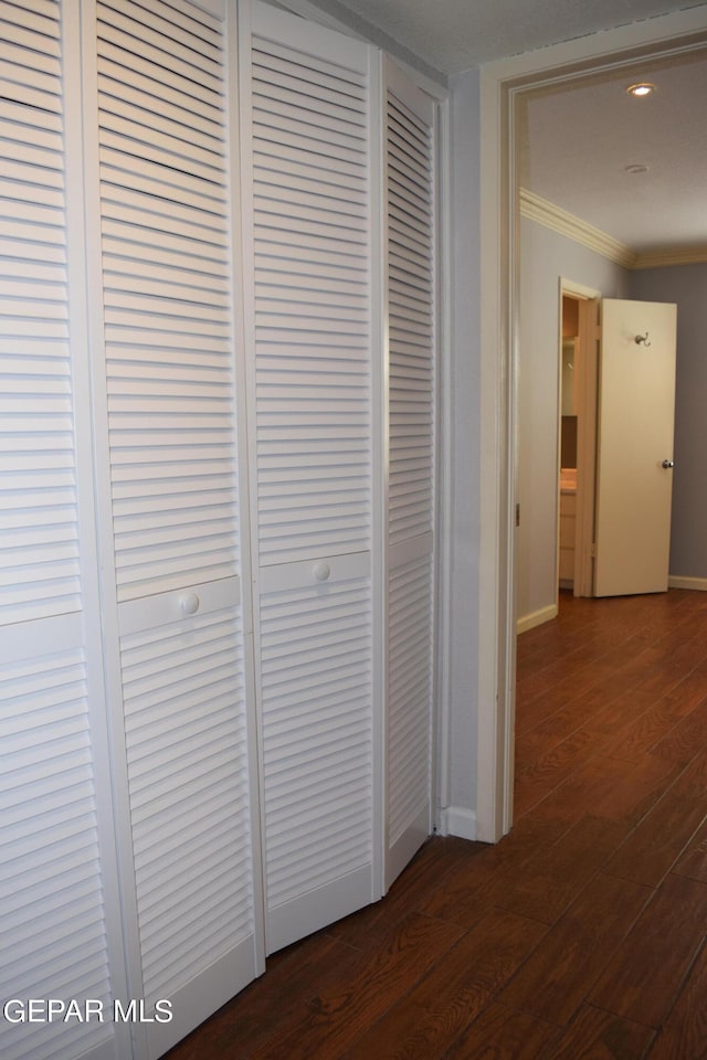 hallway featuring crown molding and dark wood-type flooring