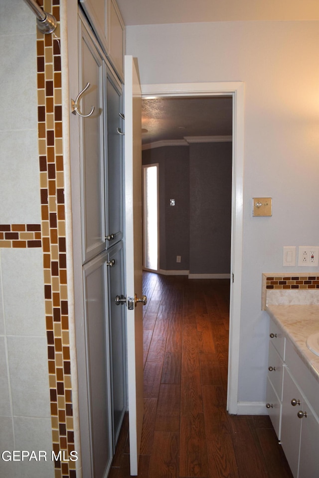 bathroom with hardwood / wood-style flooring, vanity, and crown molding