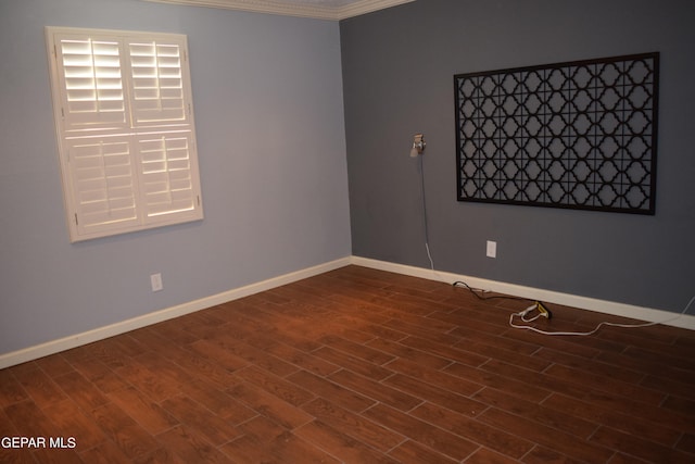 empty room featuring ornamental molding and dark hardwood / wood-style flooring