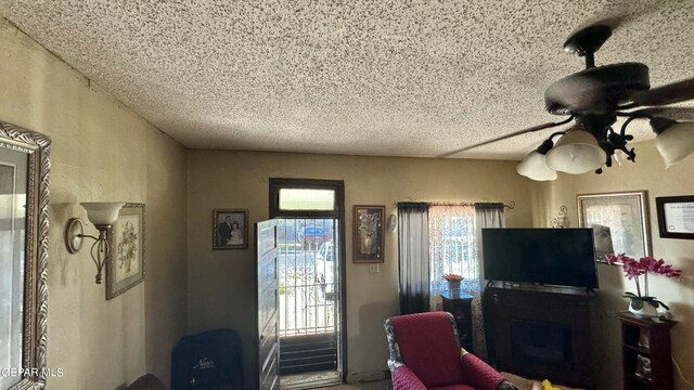 living room with ceiling fan and a fireplace