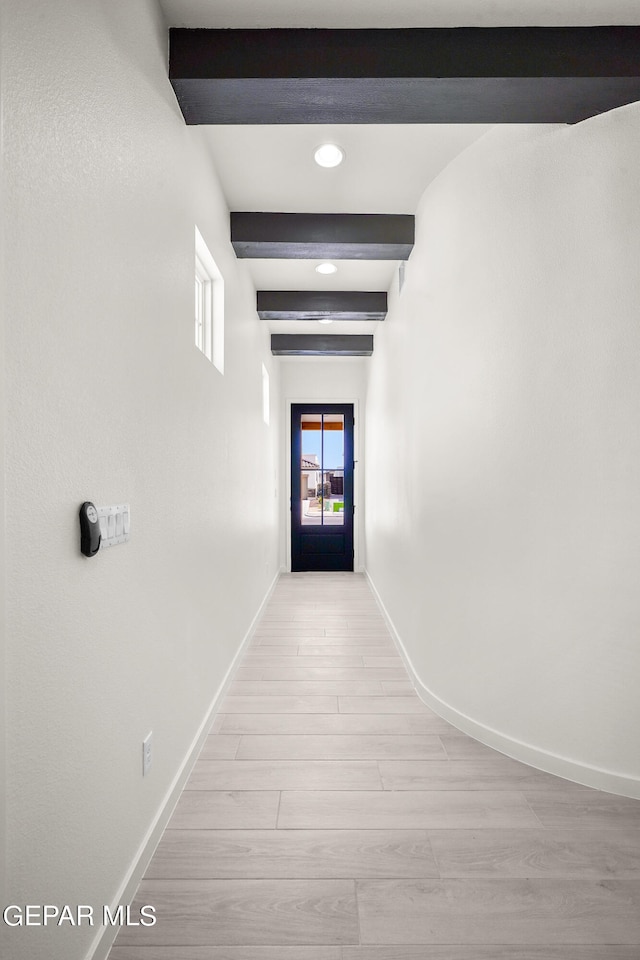 corridor featuring beamed ceiling and light hardwood / wood-style flooring