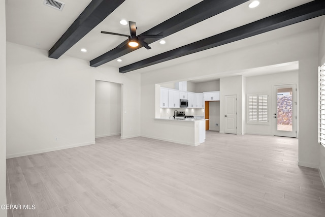 unfurnished living room featuring beam ceiling, light hardwood / wood-style floors, and ceiling fan