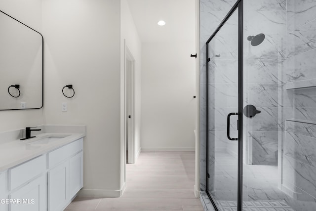 bathroom featuring walk in shower, vanity, and hardwood / wood-style flooring