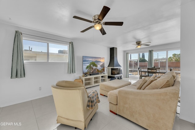 living room featuring ceiling fan, light tile patterned floors, and a wood stove