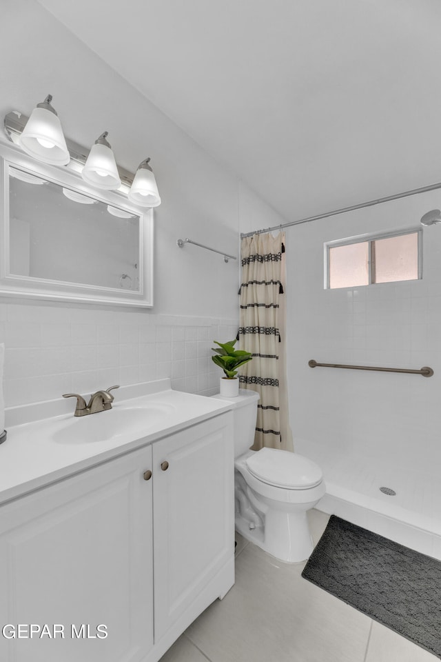 bathroom featuring tile walls, vanity, walk in shower, toilet, and tile patterned floors